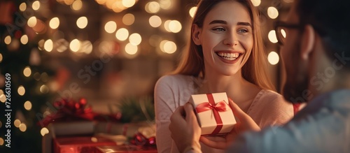Happy young couple giving valentine gifts in romantic atmosphere on bokeh background. AI generated