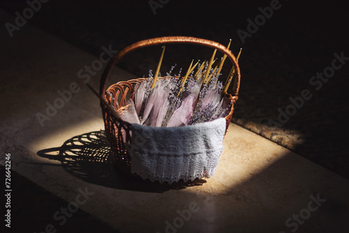 A basket with candles decorated with lavender bouquets in the Church. Accessories for an Orthodox ritual. Preparation for the child's baptism ceremony.