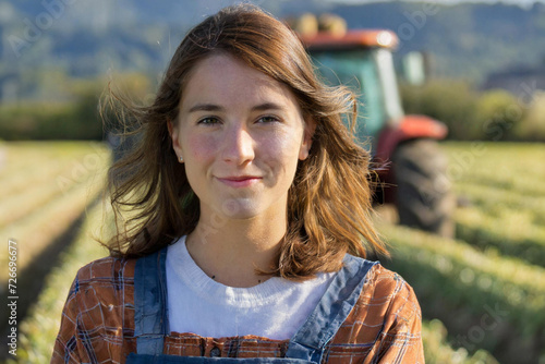 jeune agricultrice devant un tracteur