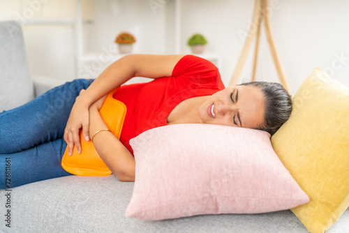 Young Woman Experiencing Menstrual Cramps on Sofa