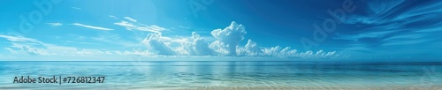 Panoramic beach landscape with the sky meeting the ocean water and a sandy deserted beach