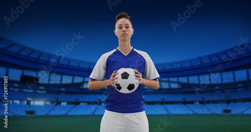 Image of biracial female soccer player over stadium