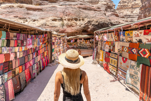 Petra, Jordan - A blonde woman looks at some market stalls where all sorts of things can be bought inside Petra, Jordan.