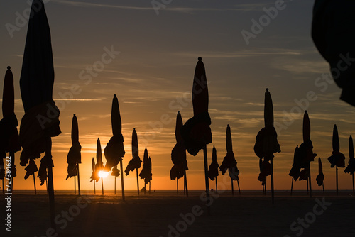 against the light of a parasol on the beach of Deauville in Normandy at sunset