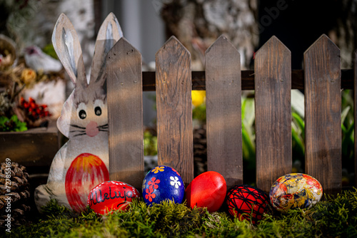 Whimsical Easter Scene: Handcrafted Eggs, Cute Bunny Cutout, and Rustic Fence