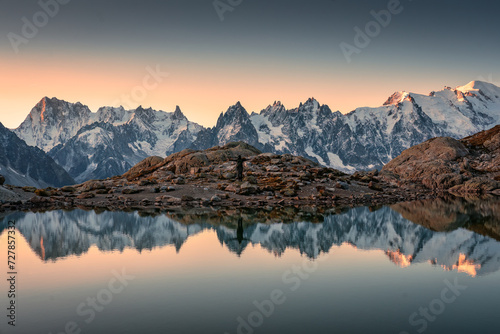 Lac Blanc with Mont Blanc mountain range and male tourist reflect on the lake in French Alps at Chamonix, France