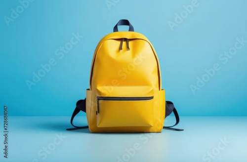 A bright yellow backpack stands against a blue backdrop, illustrating simplicity and modern lifestyle.