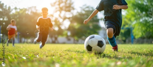 Happy children playing soccer football on outdoor grass field. AI generated image