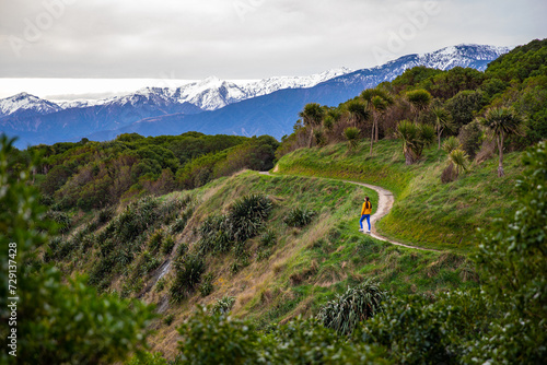 hiker girl enjoying a walk on kaikoura coast track in canterbury, new zealand; scenic track on famous peninsula with fur seal colony