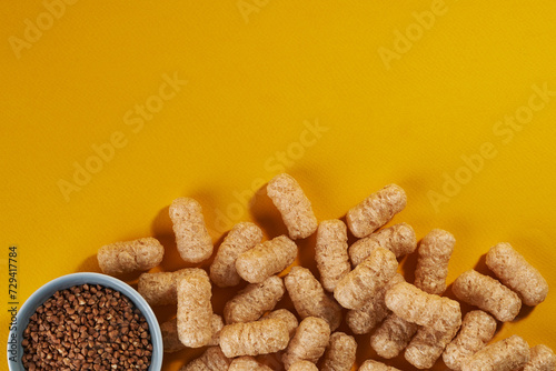 corn puffs with buckwheat on yellow background. top view