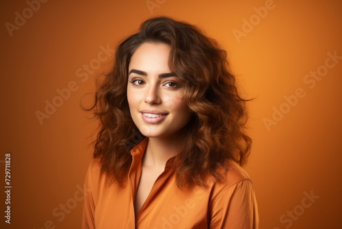 Portrait of happy smiling beautiful young woman, over orange background.