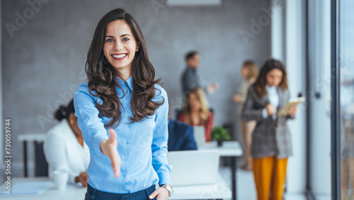 Businesswoman Offering Handshake, woman stretching out hand for shaking hello gesture, feeling satisfied welcoming new client or getting acquainted indoors.