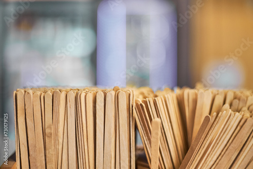 Lots of Wooden disposable stirrers for drinks, tea. Coffee area in a gas station store. stir sticks at self-service zone in cafe, coffee shop or restaurant. Eco friendly recyclable material