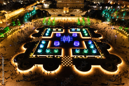 Aerial view to largest light and music fountain in Russia. 2214 colours jets burst into sky with musical accompaniment. Night show fire on the water in Nizami Ganjavi Park Derbent, Dagestan, Europe