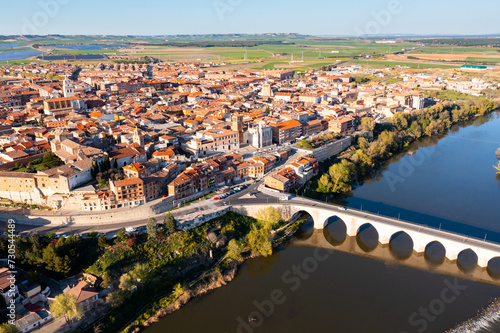Scenic drone view of small ancient Spanish town of Tordesillas on banks of Duero river in province of Valladolid on sunny spring day..