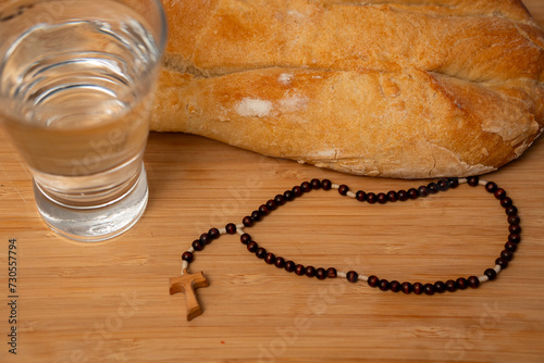acercamiento de pan y agua y rosario listos para el ayuno para ayunar en cuaresma signos religiosos católicos sacrificio y oración