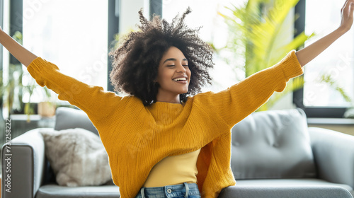 Mulher afro feliz relaxando no sofá de casa