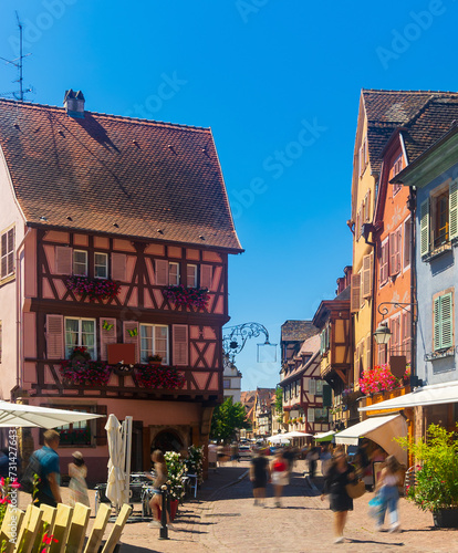 Picturesque summer cityscape of Colmar overlooking cobbled streets with typical residential townhouses on sunny day, France.
