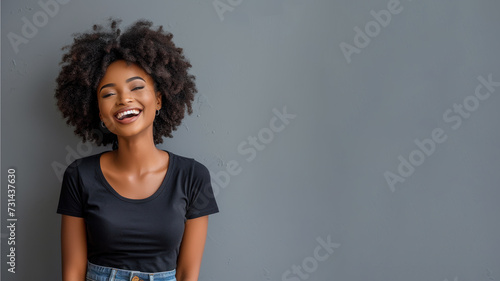 Afro young woman wear black t-shirt smile isolated on grey background