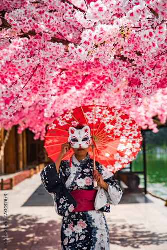 Asian girl in kimono and umbrella in Japanese theme park Hinoki Land in Chai Prakan District, Chiang Mai, Thailand
