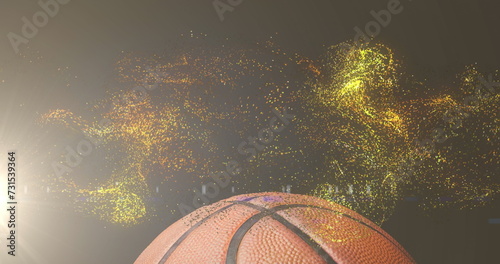 Image of glowing gold particles moving over basketball