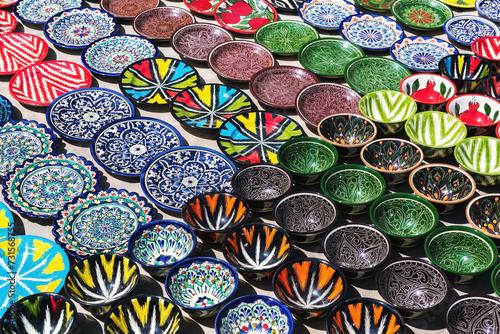 Traditional ceramics, typical handicraft uzbek souvenir. Multicolored pots and plates in Bukhara street market. Uzbekistan