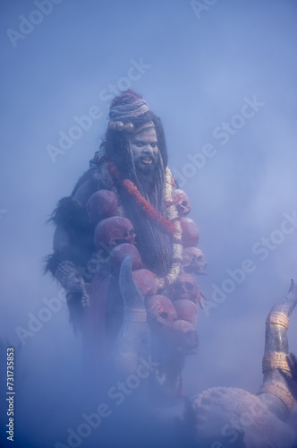 Masan Holi, Portrait of an male artist act as lord shiv with dry ash on face and body also in air while celebrating the masan holi as tradition at Harishchandra ghat in varanasi, India.