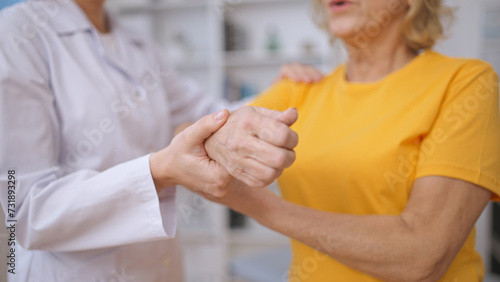 A rehabilitation expert assists a patient with stretching arm muscles following injury treatment