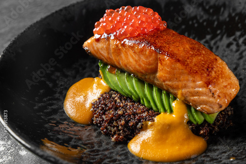 Fried salmon steak with caviar and avocado