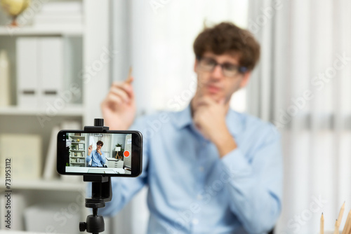 Host channel of influencer using smartphone blurred image, streaming online broadcast in sales and marketing planning focusing portrait face background on social media at modern home office. Gusher.