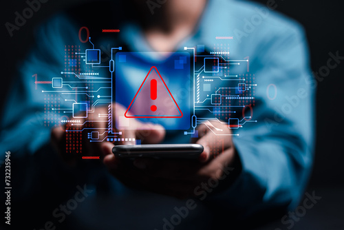 System hacked warning alert. Person use smartphone with virtual warning sign for cyber attack. Ransomware, Virus, Spyware, Malware or Malicious software, Data breach, Cyber security and cybercrime.