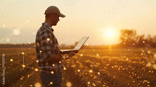 Application of new technologies in agribusiness. The farmer uses a laptop on the background of the field 