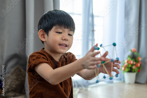 Asian boy playing with plasticine in the room