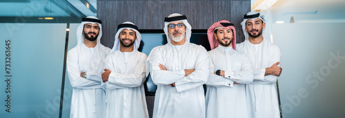 Group of corporate arab businessmen meeting in the office - Business people wearing emirati clothing working in the office