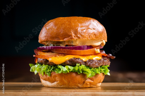 Bacon cheeseburger on a wooden board in a restaurant