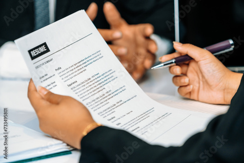 Human resources department manager reads CV resume document of an employee candidate at interview room. Job application, recruit and labor hiring concept. uds