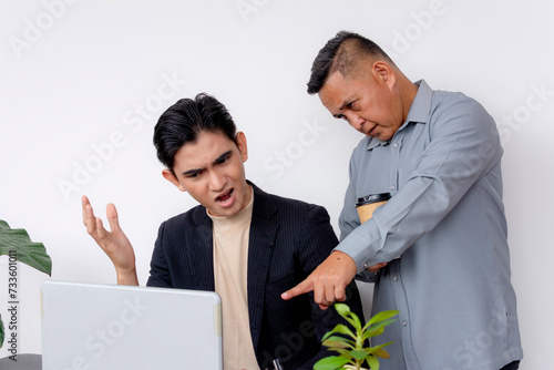A young asian male employee argues with his stubborn boss about data numbers on the laptop.