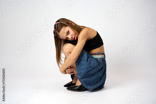 Portrait of a cute girl wearing high heels shoes and denim skirt with summer top.
