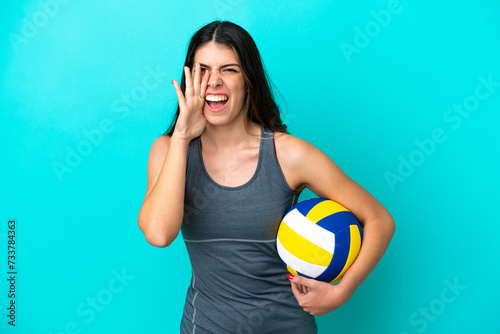 Young Italian woman playing volleyball isolated on blue background shouting with mouth wide open