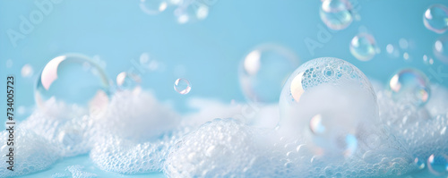 Frame with soap foam and bubbles made of shampoo, lotion, detergent. Macro photo of spume on blue background. Banner with copy space for laundry, cleaning services, beauty, skin care concept 