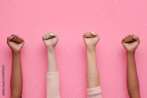 Raised fists of women on a pink background, girl power