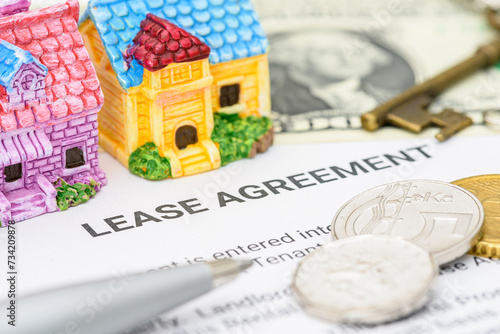 Business legal document concept : Pen, coins, key on a lease agreement form. Lease agreement is a contract between a lessor and a lessee that allow lessee rights to use of a property owned by lessor.