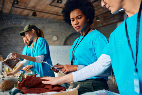 African American woman coordinating group of volunteers at charitable foundation.