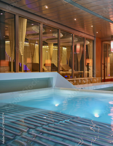 Indoor swimmingpool with hot tub whirlpool inside thermal suite in spa or wellness area onboard luxury modern cruiseship or cruise ship liner for beauty and balance