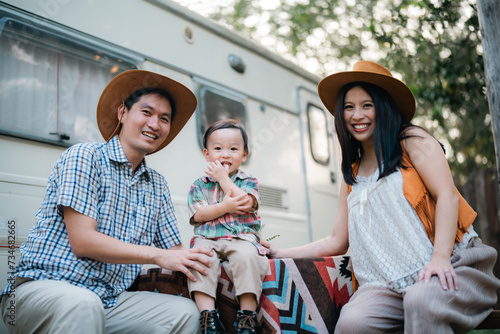 An Asian multiracial family with children are camping in nature on a road trip. Dad and mom daughter and son in the woods in the summer. Selective focus
