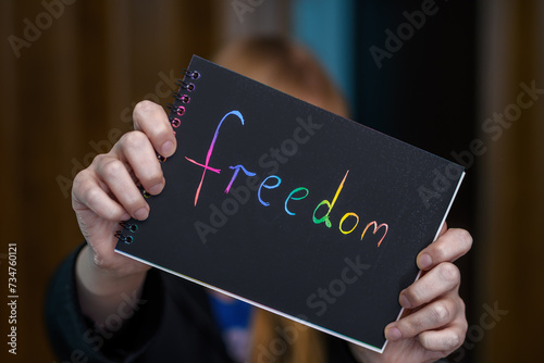 Napis na kartce wolność trzymany w dłoniach, freedom