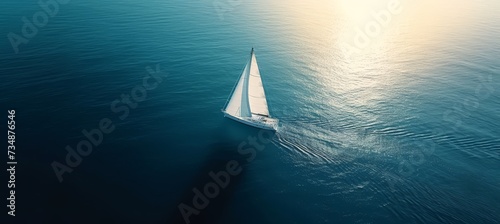 Aerial view of single sailing yacht with white sails on high seas, regatta sailboat with copy space