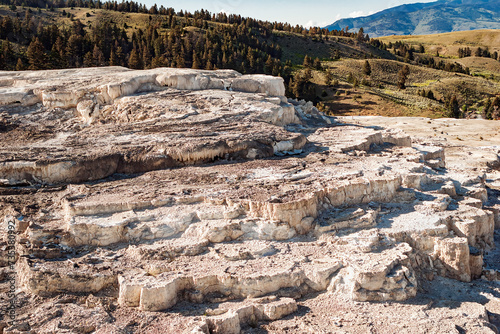 Dry mineral terraces and mountains on top of Mammoth Hot Springs during summer in Yellowstone National Park Wyoming, USA 