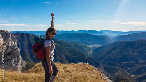Hiker woman on golden alpine meadow with scenic view of Hochschwab mountain range, Styria, Austria. Hiking trail in alpine terrain. Remote Austrian Alps in summer. Escapism. Connect with nature