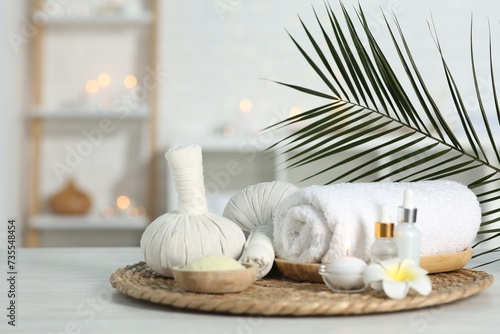 Composition with different spa products and plumeria flower on white table indoors